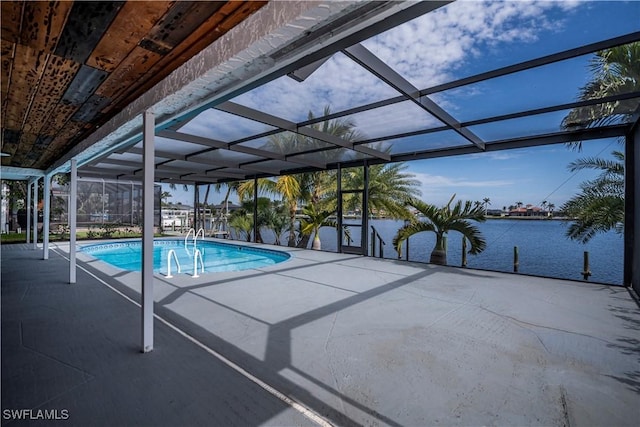 outdoor pool featuring a lanai, a patio area, and a water view