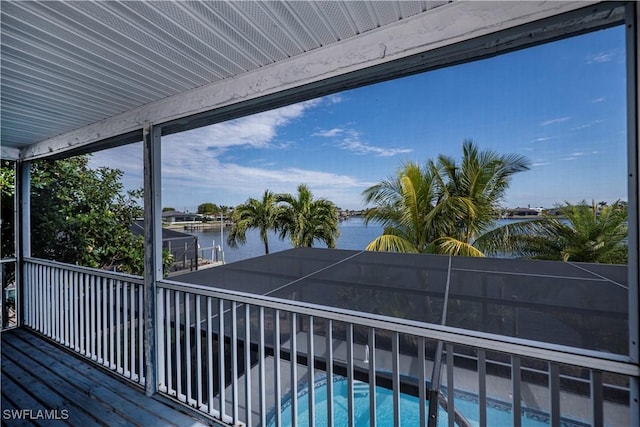 wooden deck featuring a lanai, a water view, and an outdoor pool