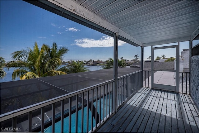 wooden deck with a water view and an outdoor pool