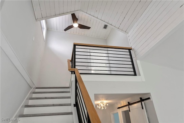 stairs featuring a ceiling fan, wooden ceiling, visible vents, and vaulted ceiling