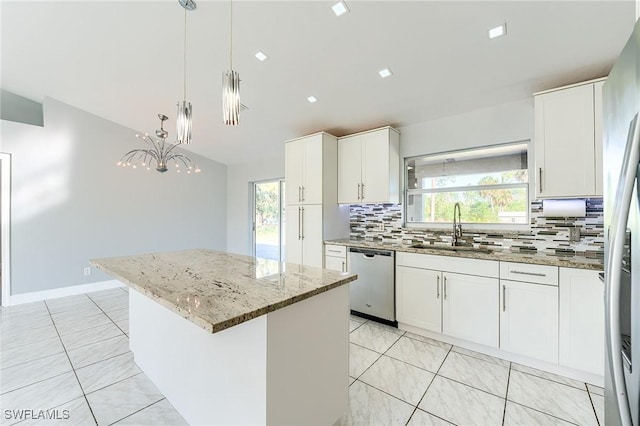 kitchen featuring white cabinets, sink, tasteful backsplash, a kitchen island, and stainless steel appliances