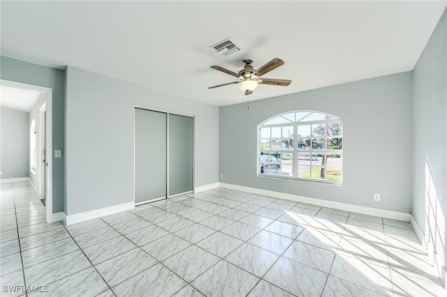 unfurnished bedroom with ceiling fan and a closet