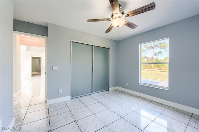 unfurnished bedroom with ceiling fan, a closet, and light tile patterned flooring