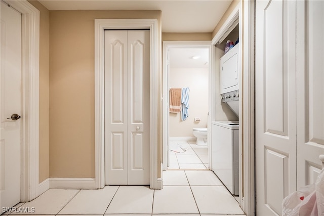 laundry room with light tile patterned floors and stacked washer and clothes dryer