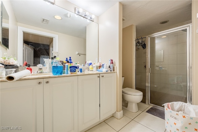 bathroom featuring toilet, tile patterned flooring, walk in shower, and vanity