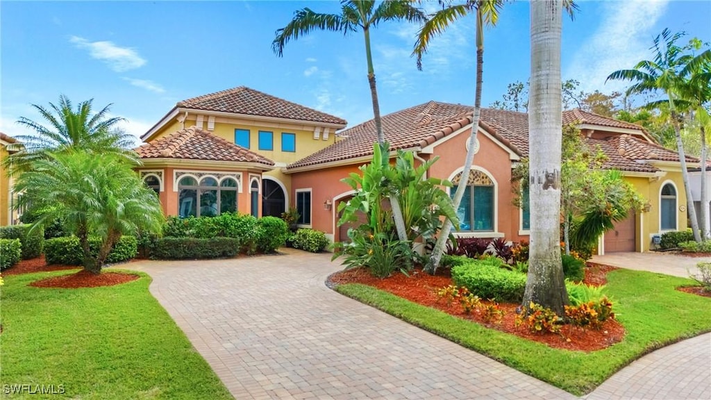 mediterranean / spanish home with a front yard and a garage