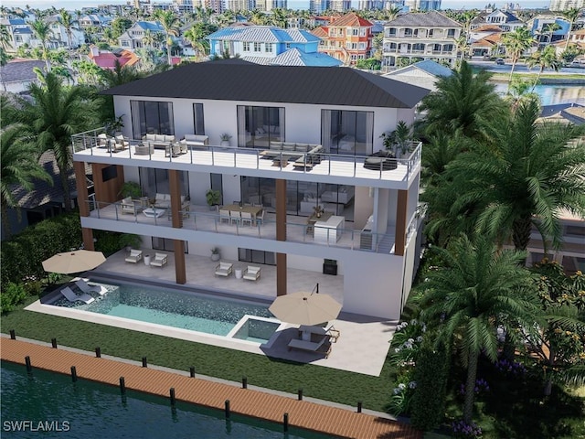 rear view of house with a balcony, a pool with connected hot tub, and a patio area
