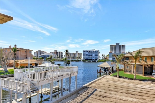 dock area with a water view, a gazebo, and a yard