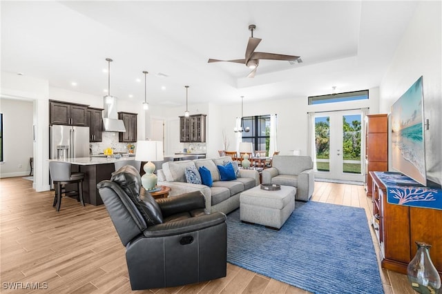 living room featuring french doors, light wood-type flooring, and ceiling fan