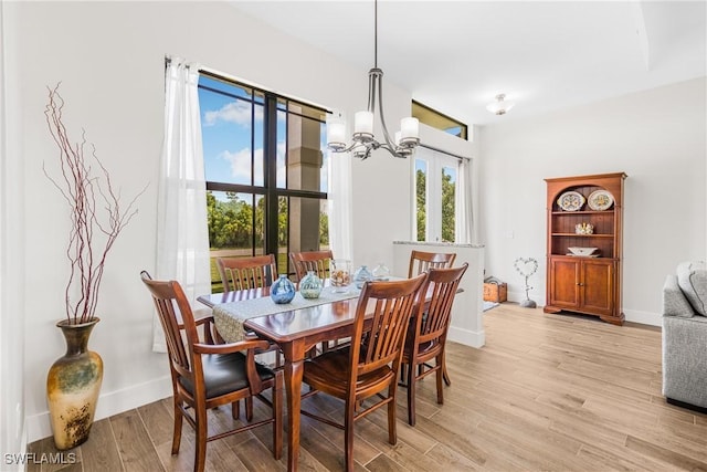 dining room with light hardwood / wood-style flooring, plenty of natural light, and a notable chandelier