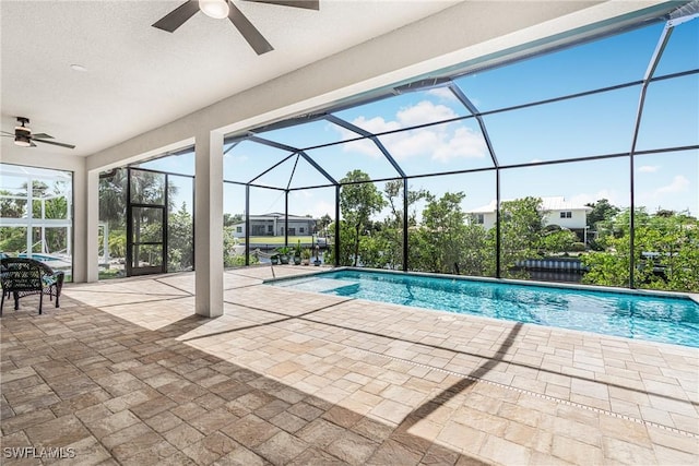 view of pool with ceiling fan, a patio, and glass enclosure