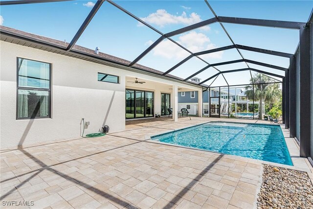 view of pool with ceiling fan, a patio area, and a lanai