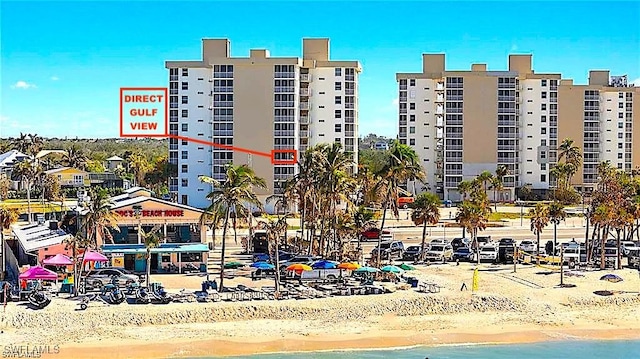 view of building exterior featuring a water view and a beach view