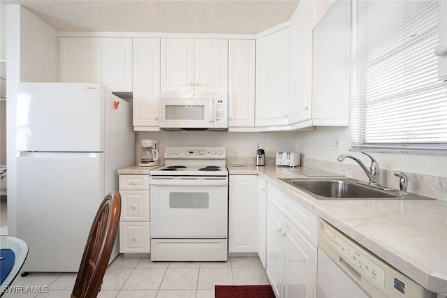 kitchen featuring white cabinets, white appliances, sink, and light tile patterned floors