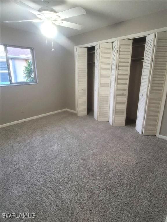 unfurnished bedroom with ceiling fan, carpet floors, and two closets