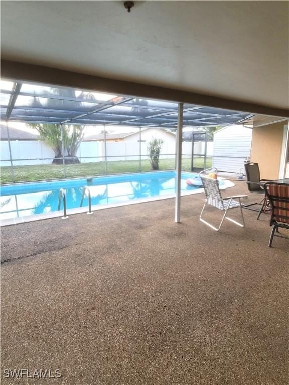 view of swimming pool featuring glass enclosure and a patio