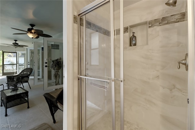 bathroom with ceiling fan, an enclosed shower, and french doors