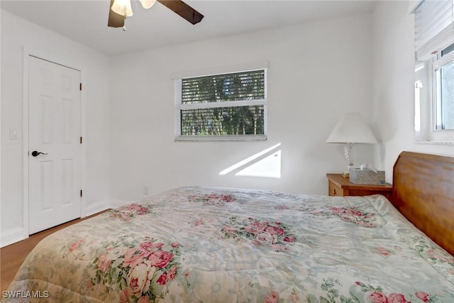 bedroom with multiple windows, hardwood / wood-style floors, and ceiling fan