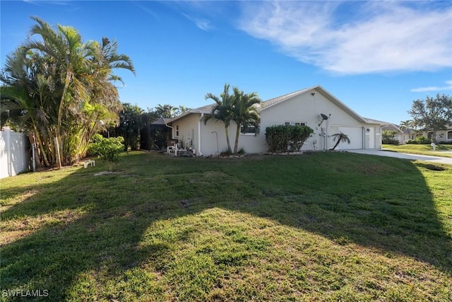 view of side of property with a lawn and a garage