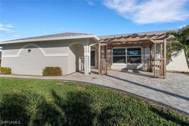 back of house featuring a lawn, a patio area, and a pergola