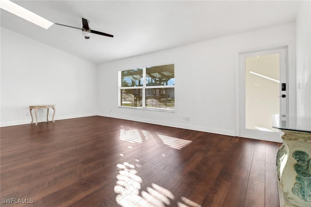 unfurnished living room featuring a skylight, ceiling fan, and dark hardwood / wood-style flooring