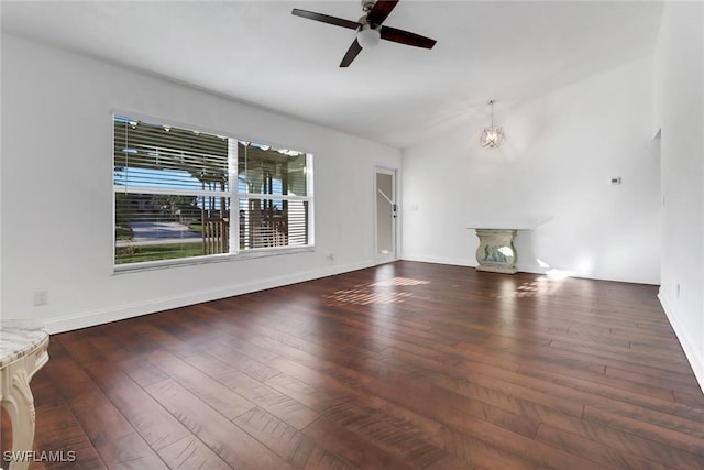 unfurnished living room featuring dark hardwood / wood-style floors, ceiling fan with notable chandelier, and vaulted ceiling