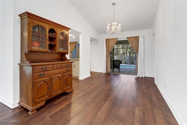 dining area with a notable chandelier, dark wood-type flooring, and vaulted ceiling