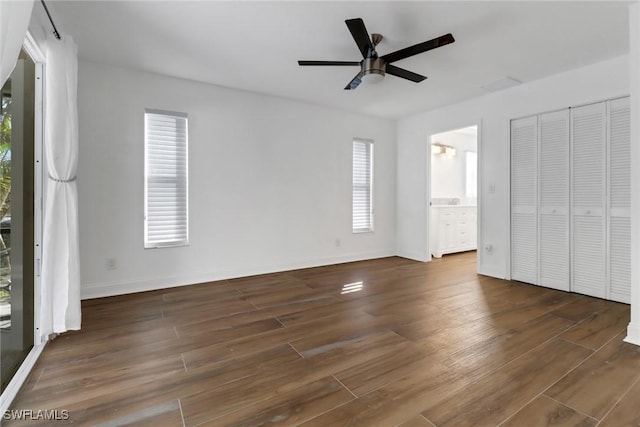 unfurnished bedroom featuring ceiling fan, connected bathroom, and multiple windows