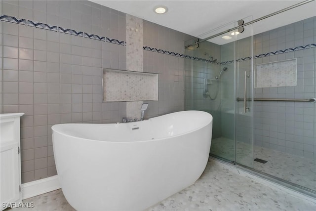 bathroom with vanity, tile walls, and plus walk in shower