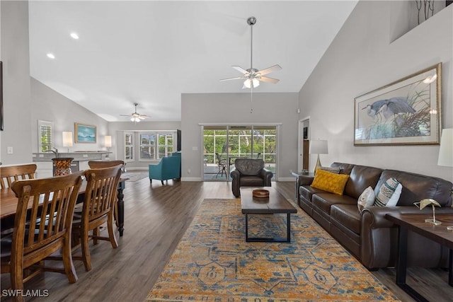 living room featuring high vaulted ceiling, ceiling fan, and dark wood-type flooring