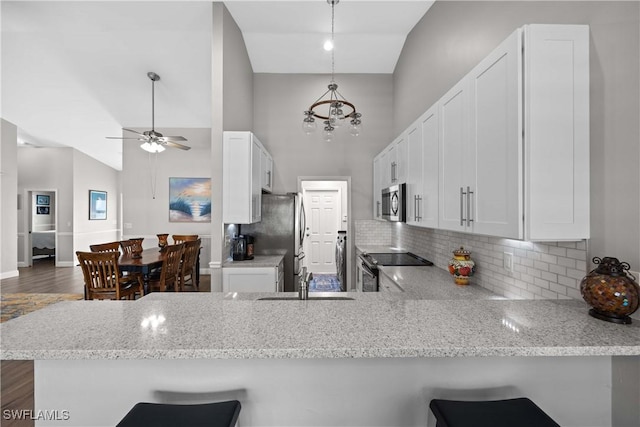 kitchen with kitchen peninsula, appliances with stainless steel finishes, and a breakfast bar area