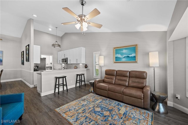 living room with ceiling fan, dark wood-type flooring, and high vaulted ceiling