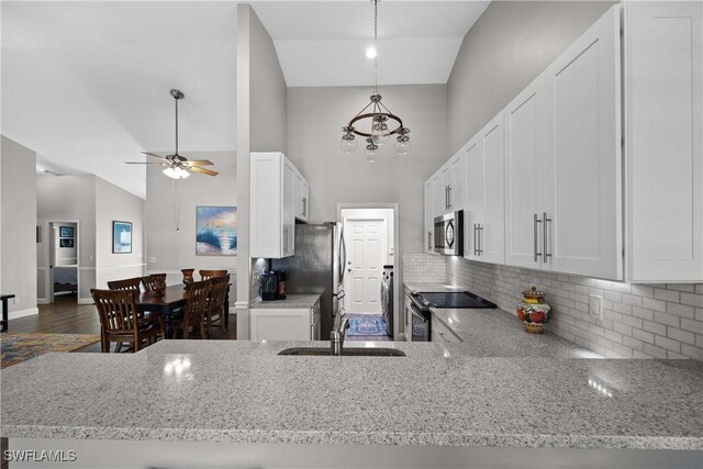 kitchen with white cabinets, sink, decorative backsplash, decorative light fixtures, and stainless steel appliances