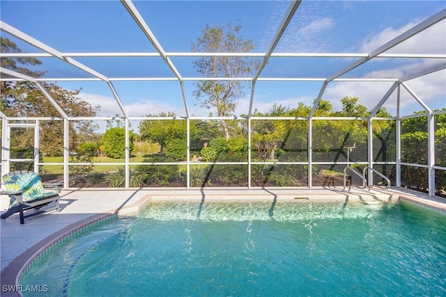 view of swimming pool featuring glass enclosure and a patio area