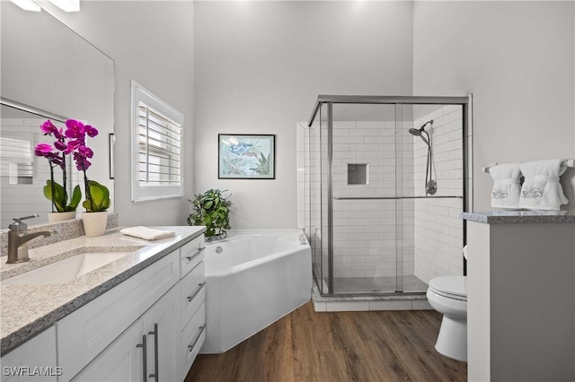 full bathroom with hardwood / wood-style floors, vanity, shower with separate bathtub, and toilet