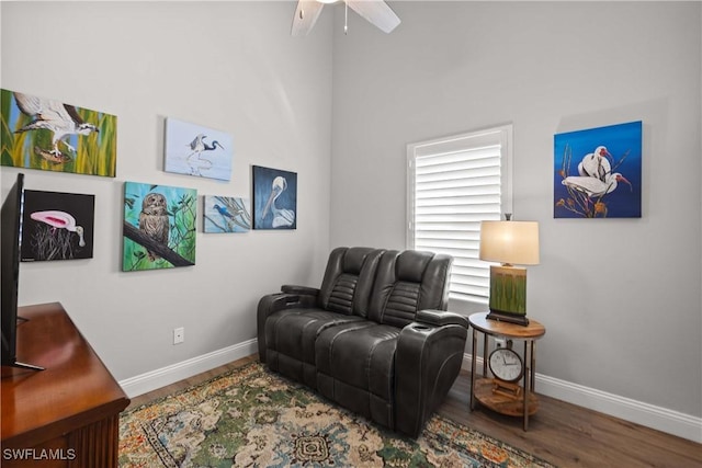 living area featuring hardwood / wood-style floors and ceiling fan