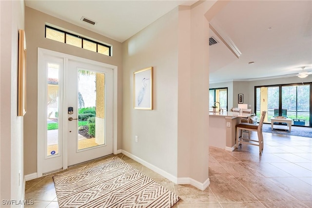 entryway featuring ceiling fan, sink, light tile patterned floors, and a healthy amount of sunlight