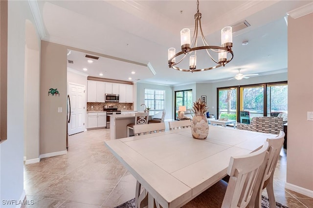 dining space featuring ceiling fan with notable chandelier, sink, and crown molding