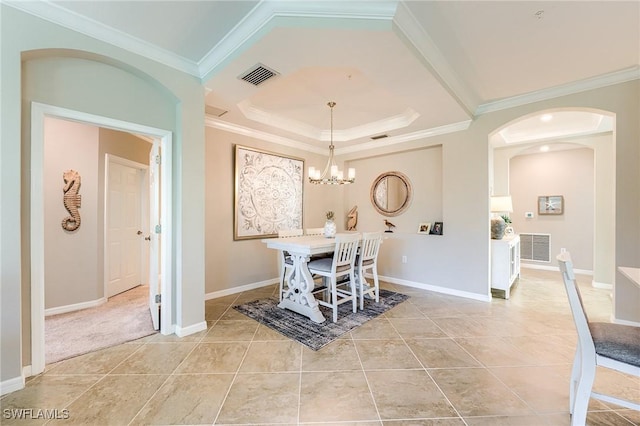 dining room featuring light tile patterned floors, a tray ceiling, an inviting chandelier, and crown molding