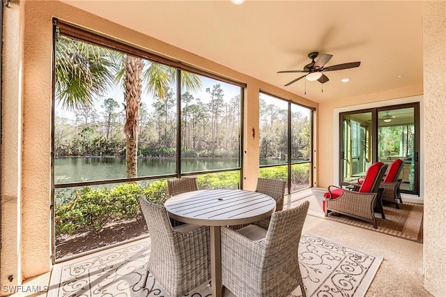 sunroom featuring a water view, plenty of natural light, and ceiling fan