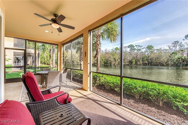 sunroom with a water view, ceiling fan, and a healthy amount of sunlight