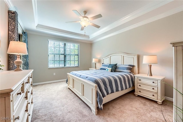 carpeted bedroom with ceiling fan, a raised ceiling, and crown molding