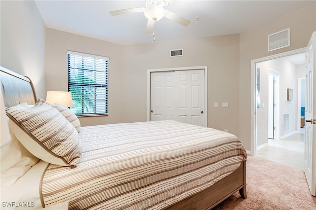 carpeted bedroom with ceiling fan and a closet