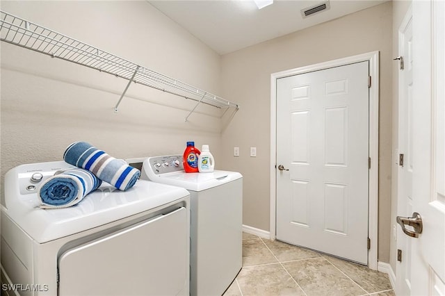 laundry room featuring washing machine and clothes dryer and light tile patterned flooring