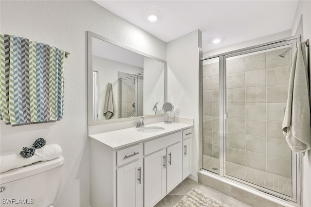 bathroom with tile patterned flooring, vanity, and walk in shower