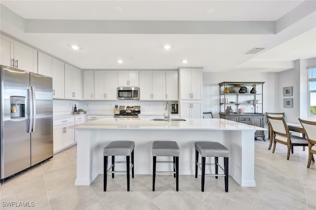 kitchen featuring white cabinetry, sink, a center island with sink, and appliances with stainless steel finishes