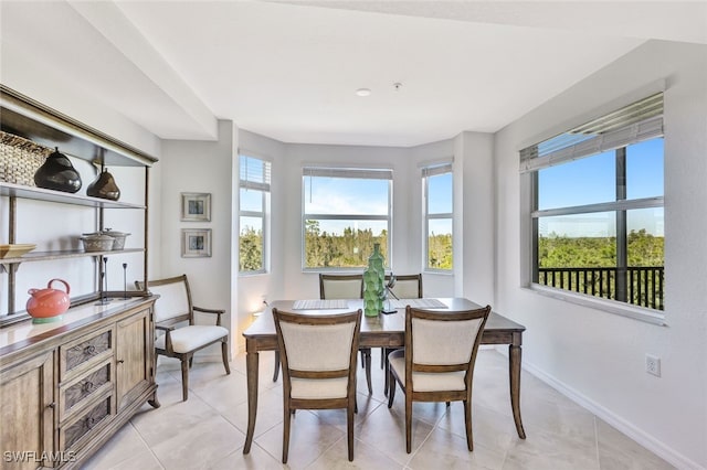 dining space featuring light tile patterned floors and a healthy amount of sunlight