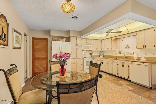 kitchen with sink, white appliances, cream cabinetry, and a textured ceiling