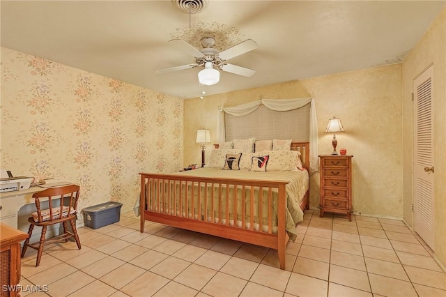 bedroom featuring light tile patterned floors, a closet, and ceiling fan