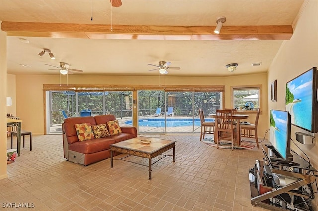 living room featuring beamed ceiling and ceiling fan